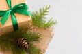 Christmas composition. Christmas gift, jute, pine cone and fir twigs on light background