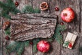 Christmas composition with Christmas gifts, bark texture, pomegranate, Fir branches on wooden background