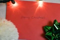 Christmas composition. Christmas hat, green bow, and an envelope with Merry Christmas written on it