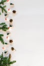 Christmas tree toys, decorative cones, fir branches and a garland of lights on a white background. Flat lay, top view, copy space Royalty Free Stock Photo