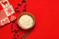 Christmas composition Cookie cutters and a bowl of flour on red background Royalty Free Stock Photo