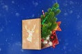 Christmas composition, covered with gift box with deer and gifts inside, blue background and snow Royalty Free Stock Photo