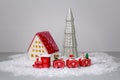 Christmas composition decorates the house. Ceramic figurines of gray and pink Christmas trees, a garland, gifts