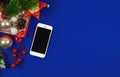 Christmas composition, decorations and smartphone, copy space, blue background, top view Royalty Free Stock Photo