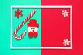 Christmas composition with decorative snowman, lollipop and snowflakes on colorful background with white frame. Winter holiday Royalty Free Stock Photo