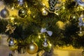 Christmas composition in the evening illumination of lighted garlands. Xmas fir tree with baubles, multi-colored bows, animals,