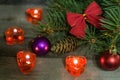 Christmas composition of fir branches decorated bows and balls with burning candles on a wooden background Royalty Free Stock Photo
