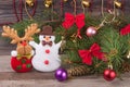 Christmas composition of fir branches decorated bows and balls with snowman reindeer on a wooden background Royalty Free Stock Photo