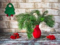 Christmas composition with fir branches in a red vase and rowan branches