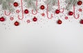 Christmas composition, fir tree branches, candy canes, round candies, red baubles, stars confetti on white background. Royalty Free Stock Photo