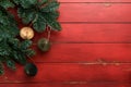 Christmas composition. Christmas fir tree branches with pine cones and papers rustic balls on wooden red rustic background Royalty Free Stock Photo