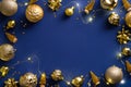 Christmas composition. Flat lay golden decorations, balls, tinsel, lights on dark blue background. Xmas frame, New Year banner Royalty Free Stock Photo