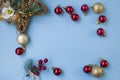 Christmas composition. Frame from branches of a Christmas tree, red and gold decorations and red berries on a white background. Royalty Free Stock Photo