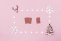 Christmas composition. Frame from white stars, snowflakes, chrismas tree and symbol of deer on pastel pink paper background. Date Royalty Free Stock Photo