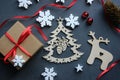 Christmas composition. Gift box with red satin ribbon, tree and snowflakes on black background. Royalty Free Stock Photo