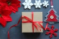 Christmas composition. Gift box with red satin ribbon, wood and snowflakes on black background. Toys Christmas decor. Royalty Free Stock Photo