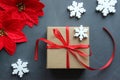 Christmas composition. Gift box with red satin ribbon, wood and snowflakes on black background. Toys Christmas decor. Royalty Free Stock Photo