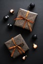 Christmas composition. Gift boxes with brown ribbon bow and bauble on dark black background. Vertical Christmas card Royalty Free Stock Photo