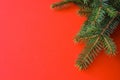 Christmas composition with gift boxes, clews of rope, paper`s rools and decorations, fir tree branches on red background.