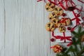 Gift boxes, homemade gingerbread in the form of Santa`s reindeer, fir branches and cones, red ribbons and bells on a light wooden Royalty Free Stock Photo