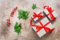 Christmas composition. Gift boxes with a red ribbon on a beige grunge background decorated with green coniferous branches. Top Royalty Free Stock Photo