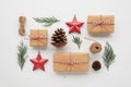 Christmas composition with gift boxes wrapped in craft paper, pine cones, conifer branches, decorative toys on white background