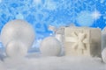 Christmas composition with gift or present box and decorative snowballs against holiday lights background Royalty Free Stock Photo