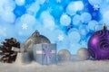 Christmas composition with gift or present box, pine cone, bell and decorative snowballs against holiday lights background Royalty Free Stock Photo