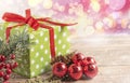 Christmas composition. Gift, for tree branches, red balls decorations on wooden background.