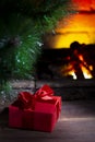 Christmas composition, gift under the tree near a burning fireplace, close-up Royalty Free Stock Photo