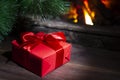 Christmas composition, gift under the tree near a burning fireplace, close-up Royalty Free Stock Photo