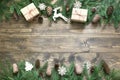 Christmas composition with giftbox, deer, natural decor and cones on wooden board with copy space. Flat lay.