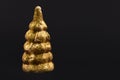 Christmas composition.Gold toy Christmas tree on a black background