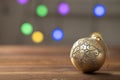 Christmas composition. Golden ball on wooden table on sparkling background