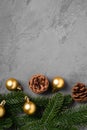 Christmas composition. Golden baubles, pine cones and fir needles decorations on grey background Royalty Free Stock Photo