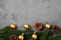 Christmas composition. Golden baubles, pine cones and fir needles decorations on grey background Royalty Free Stock Photo