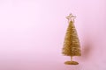 Christmas composition. Golden christmas tree decoration with glitters on pink pastel background. Mock up for new year gretting