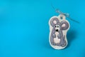 Handmade gingerbread in the form of a funny gray rat with a silver bow on a light blue background. Christmas, winter, New year. Royalty Free Stock Photo