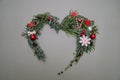 Christmas composition. Heart symbol made of pine, cypress, thuja branches branches, balls, berries and wood decorations. Christmas