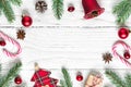 Christmas composition made of fir branches, decorations, berries, candy, gift boxes and pine cones on white wooden table Royalty Free Stock Photo