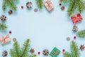 Christmas composition made of frame of fir branches, red berries, gift boxes and pine cones Royalty Free Stock Photo
