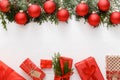 Christmas composition made of red Christmas gifts, red bauble decorations, fir tree branches on white wooden table background. Royalty Free Stock Photo