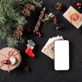 Christmas composition with mobile phone, money euro, Fir branches, gifts, red decorations on dark background Royalty Free Stock Photo