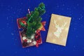 Christmas composition, open gift box with deer and gifts inside, blue background and snow Royalty Free Stock Photo