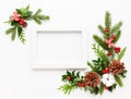 Christmas composition  with photo frame, cotton flower, branches of spruce and holly with red berries on white background. Merry Royalty Free Stock Photo