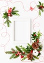 Christmas composition  with photo frame, cotton flower, branches of spruce and holly with red berries on white background. Merry Royalty Free Stock Photo