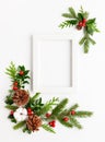 Christmas composition  with photo frame, cotton flower, branches of spruce and holly with red berries on white background. Merry Royalty Free Stock Photo