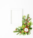 Christmas composition  with photo frame, cotton flower, branches of spruce and holly with red berries on white background. Merry Royalty Free Stock Photo