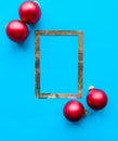 Christmas composition. Photo frame and red baubles on bright blue background. Royalty Free Stock Photo