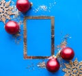 Christmas composition. Photo frame and red baubles on bright blue background. Christmas, winter, new year concept. Royalty Free Stock Photo